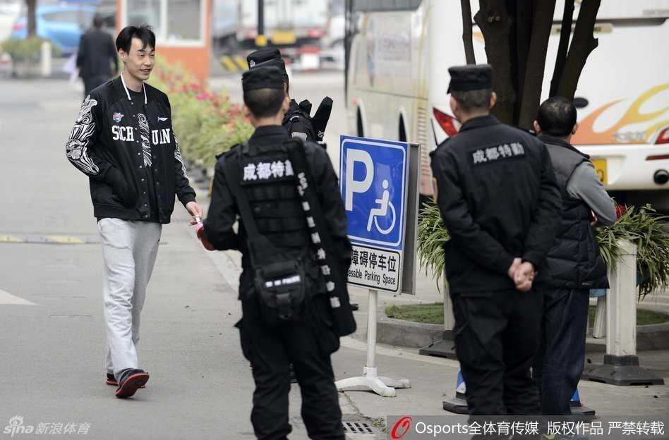 老将孟达在前往训练途中，面对身旁全副武装的执勤特警，神情轻松地露出微笑，仿佛外界的喧嚣与紧张都与他无关。