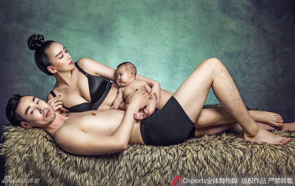 一家三口穿着帅气的西装坐在沙发上，妈妈倚靠在爸爸肩头，孩子坐在中间，画面既温馨又充满时尚感