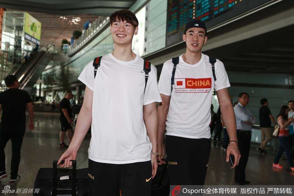 队长周鹏独自推着行李，神情专注而坚毅，深色的运动外套让他显得更加沉稳，仿佛在沉思着即将到来的欧洲拉练与里约奥运会的严峻挑战。