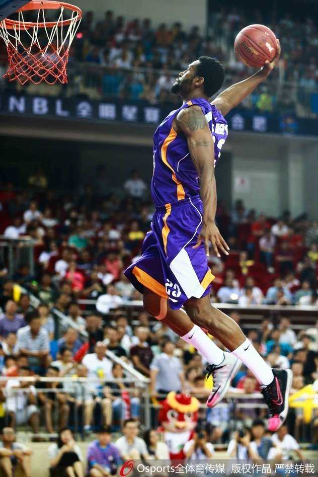 篮球场上的进攻艺术:从飞身暴扣到篮下终结 进攻球员在三人包夹之下,依然冷静地将球放入篮筐,展现出极佳的空中平衡感。