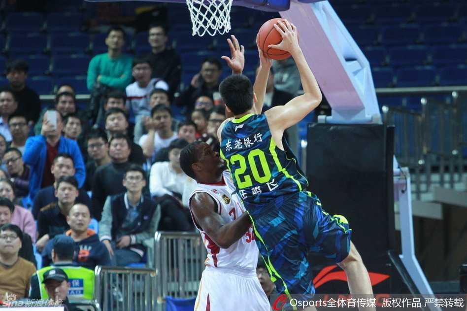 周鹏持球强行突破，面对两人包夹防守，在空中奋力维持平衡，将球抛向篮筐。