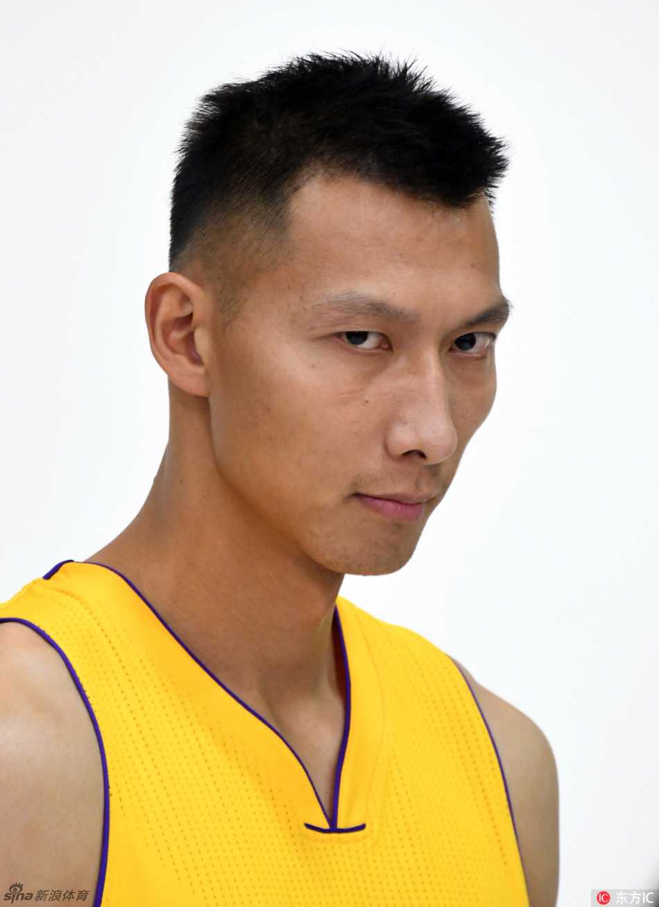 易建联身穿湖人11号战袍，在摄影棚内手持篮球，目光坚毅地凝视前方，仿佛在凝视着新赛季的重重挑战。