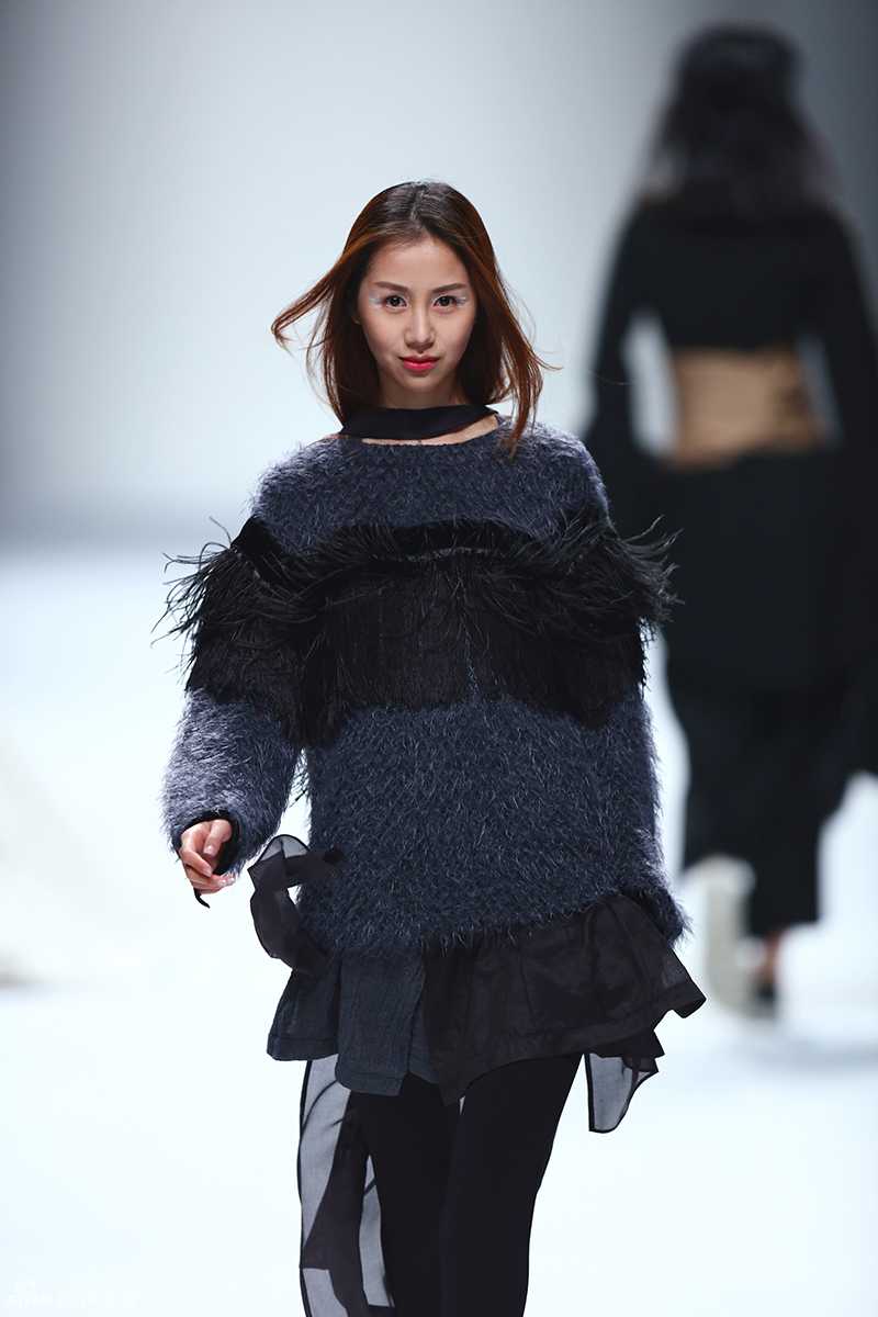 后台化妆间的灯光下，陈露端坐在镜子前进行补妆，手拿粉扑轻轻按压面部，神情专注而从容，展现出专业模特在幕后的严谨与敬业