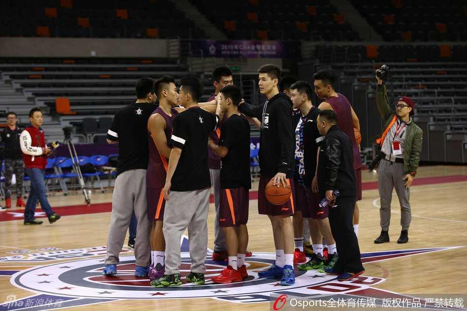 名宿胡雪峰身披北区队训练服，双手叉腰神情专注地在场边监督弟子们热身，眼神中透露出对这批年轻才俊的期望