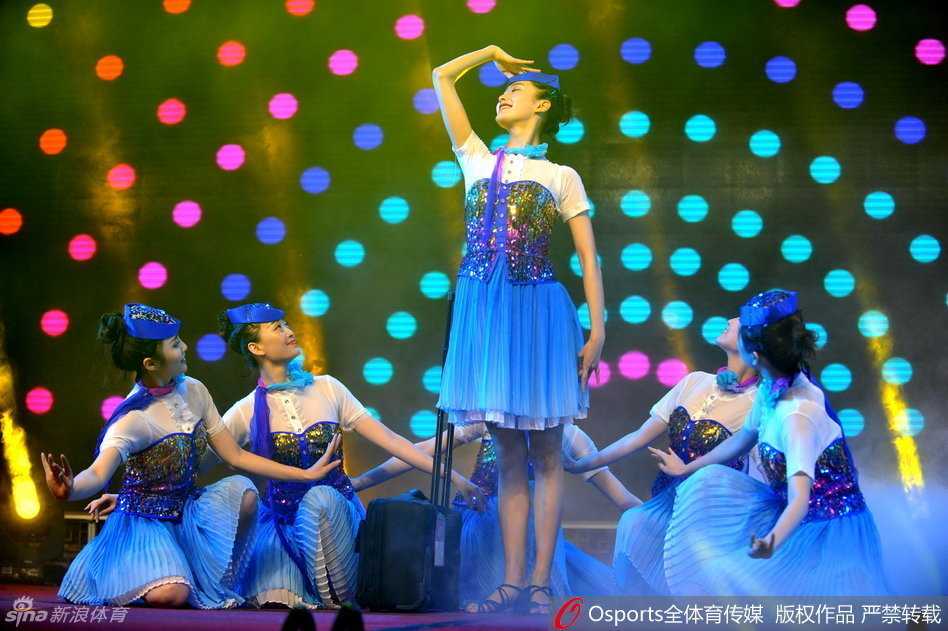 四川金强队的球员们笑容满面地站在台上，与刚刚表演完的空姐们亲切合影。背景是庆功会现场，每个人的脸上都写满了夺冠后的喜悦与放松。