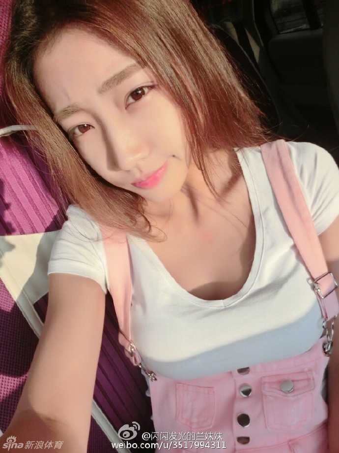 一位吉林篮球宝贝在训练间隙休息，她坐在场边地板上，用手轻轻揉着因反复跪地动作而泛红的膝盖，但脸上依然挂着满足而平静的微笑。