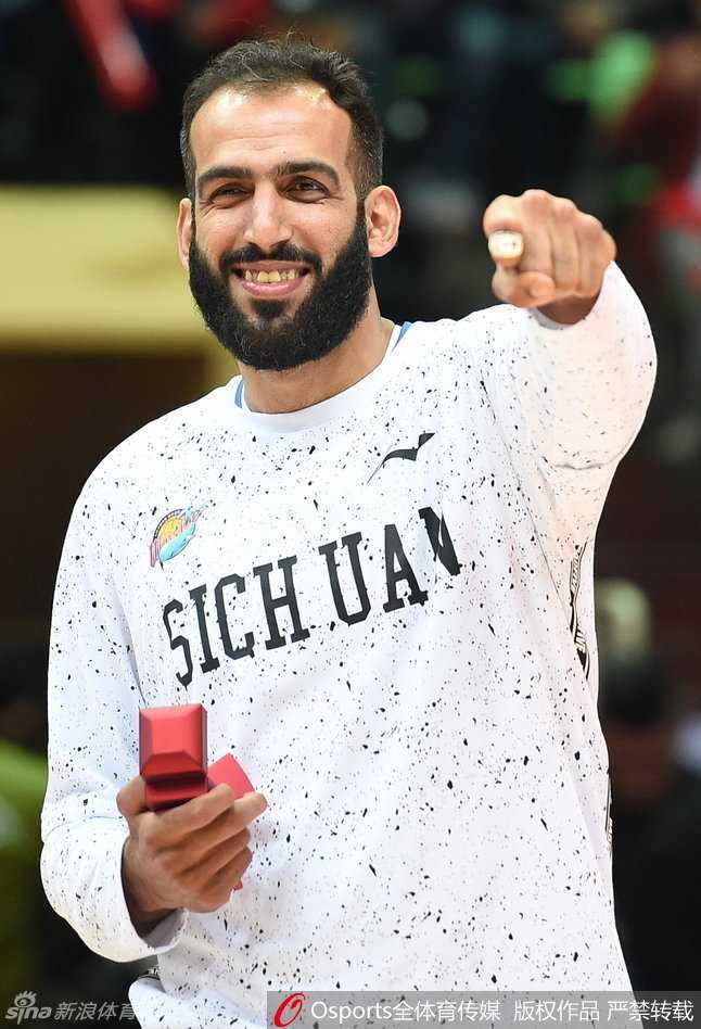 四川金强男篮将帅齐聚一堂，在璀璨的聚光灯下集体展示刚刚获得的总冠军戒指，这张全家福定格了球队历史上最辉煌的荣耀瞬间。