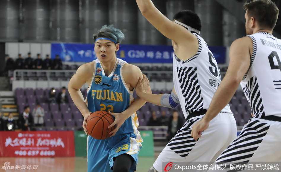 辽宁队主帅郭士强在场边神情专注，弯下腰对着场内球员大声呼喊，进行即时战术指导。