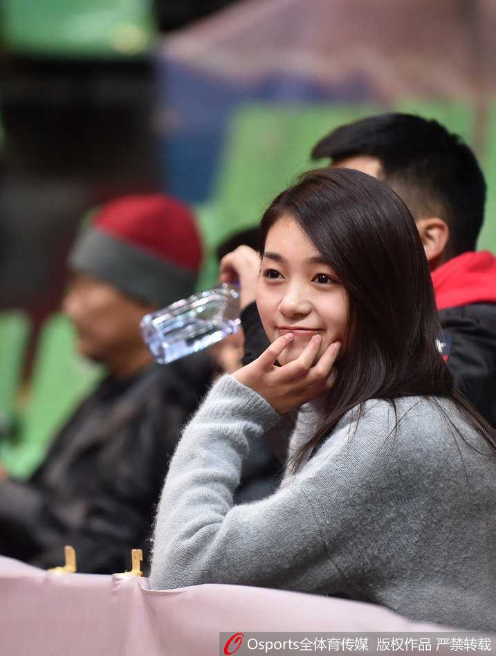 在四川主场一片黄色的助威海洋中，一位面容清秀的女球迷正全神贯注地盯着赛场，她紧抿着嘴唇，双手合十放在胸前，仿佛正在为球队的每一次进攻默默祈祷。