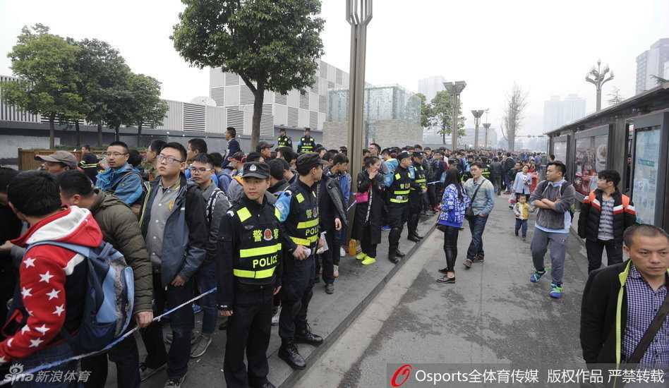 天边已泛起鱼肚白，经过一整夜的坚守，终于轮到了队伍最前面的这位男球迷。他一手拿着身份证，一手递出钱款，神情专注而坚定，仿佛在进行一项无比神圣的仪式。