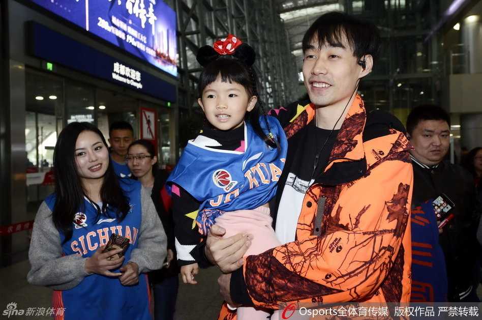 四川队主帅杨学增面带谦和的微笑，与前来接机的热情球迷亲切握手，身后是刚刚走出机场通道的冠军队伍成员们。