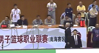 广东队主教练杜锋在比赛中焦急地向技术台做出请求录像回放的手势，他双手比划着矩形框，脸上写满了恳切与不满，身后的球员也情绪激动地看向同一个方向。