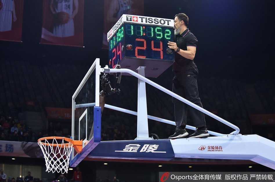 工作人员成功拿到篮球后，场下的丁彦雨航和队友们仰头观望，脸上带着轻松的笑容