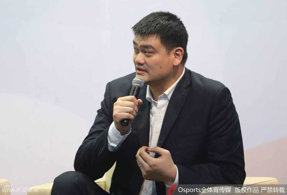 在论坛互动环节，姚明与身边嘉宾交流看法，他面带标志性的亲和微笑，双手自然交叠，西装革履的形象展现了他作为投资人的沉稳与睿智。