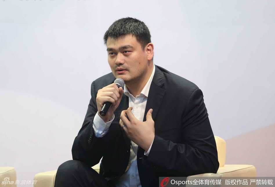 镜头捕捉到姚明在论坛上的一个瞬间，他双手扶住桌面，身体微微前倾，正专注地聆听台上嘉宾关于资本入局CBA的见解，神情认真而轻松。