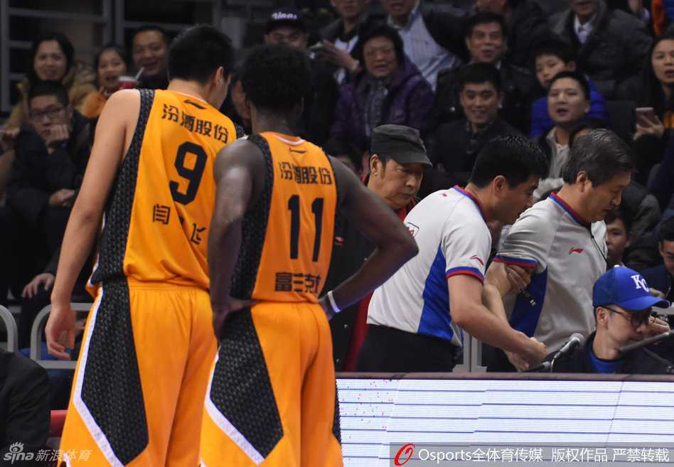 受伤裁判在同事搀扶下步履蹒跚地离场，身后的比赛即将恢复，但他的执法之夜已提前结束