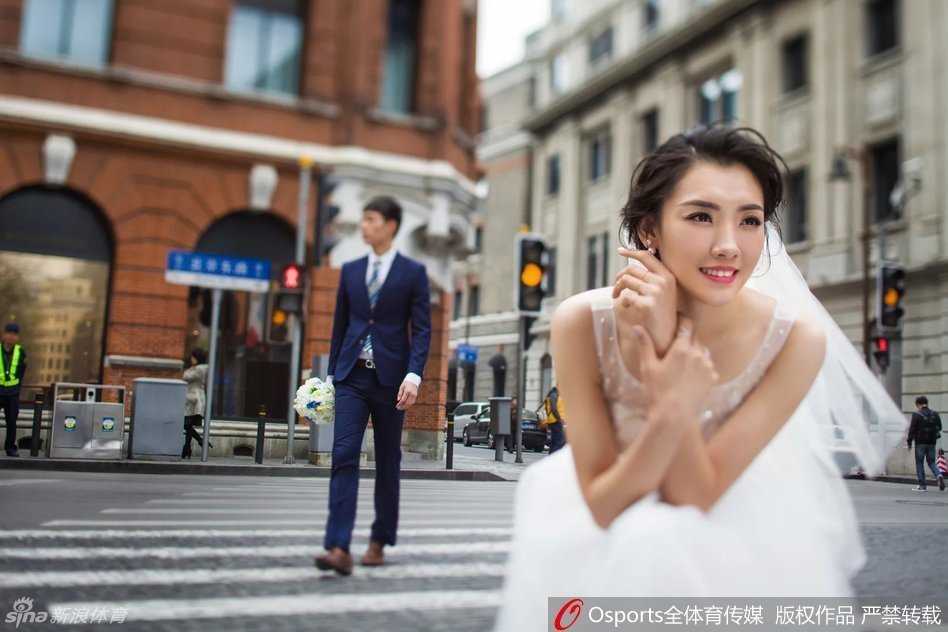 新娘张薇一袭简洁的缎面婚纱，手持简约手捧花，独自立于落地窗前，阳光勾勒出她优美的身形曲线，面容恬静而充满对未来的憧憬。