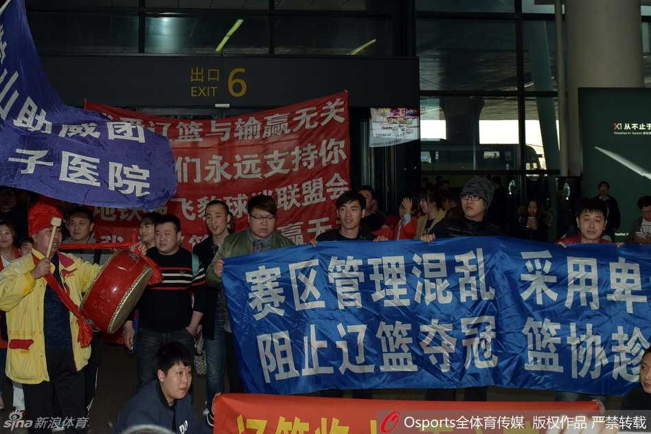 辽沈球迷含冤接机,标语声声讨伐篮协不作为 尽管辽篮最终被迫从贵宾通道离开,但大批痴心的球迷依然不肯散去,他们高举着手机和标语,目光紧紧追随着球队大巴离去的方向。