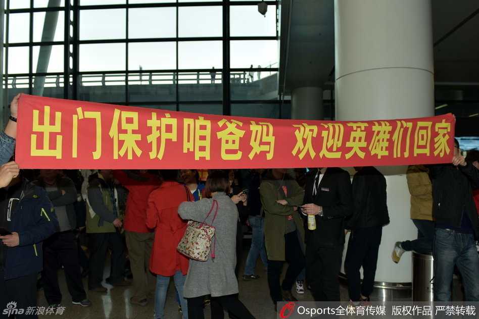 辽沈球迷含冤接机,标语声声讨伐篮协不作为 数名年轻球迷并肩站立,他们手中高举着“削他”和抗议篮协的标语牌,脸上写满了愤怒,用最直接的家乡口号表达着对客场所遭遇的不公。