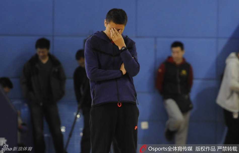 功勋后卫杨鸣正在进行训练前的拉伸，神情专注而放松，作为球队的老将，他一丝不苟地完成着每一个准备动作。