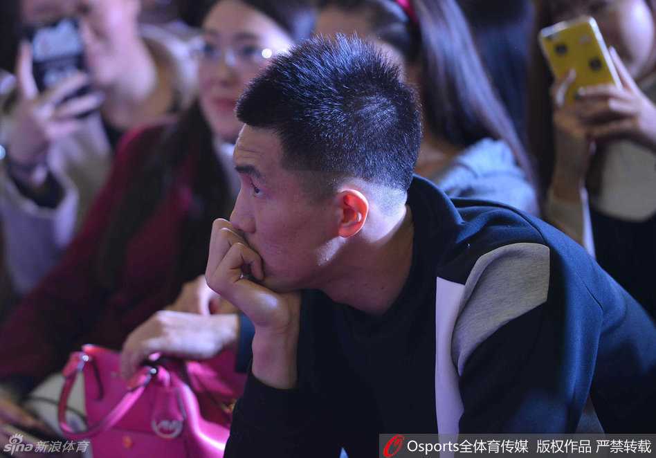 郭艾伦将手机套高高举起，面向粉丝展示，脸上洋溢着俏皮的笑容，仿佛在炫耀自己的新宝贝。