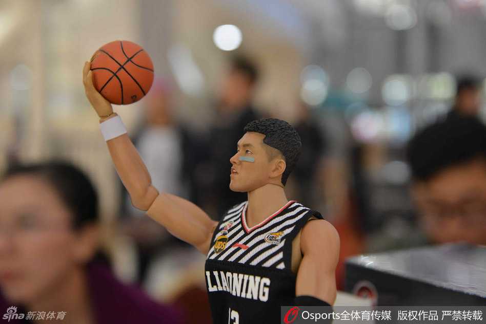 发布台前，一位长发披肩的美女球迷双手轻抚着郭艾伦人偶的头部，眼神里满是见到偶像的温柔与惊喜，仿佛在与缩小版的艾伦进行无声对话。