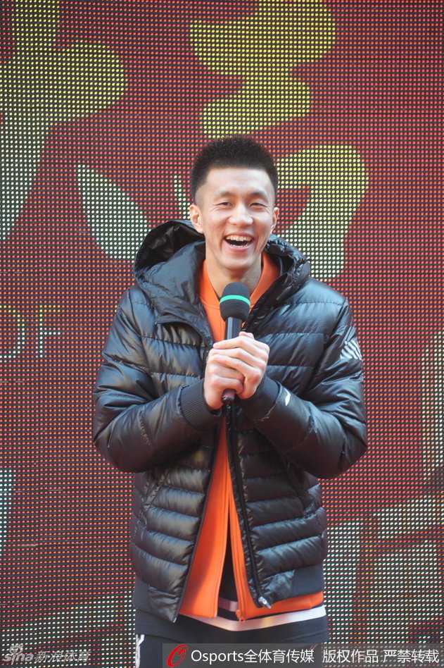 郭艾伦现身活动现场，他身着醒目的绿色外套，瞬间被热情的红色人海包围，正微笑着为前排的球迷签字，寒冷的气温与现场炽热的气氛形成鲜明对比。