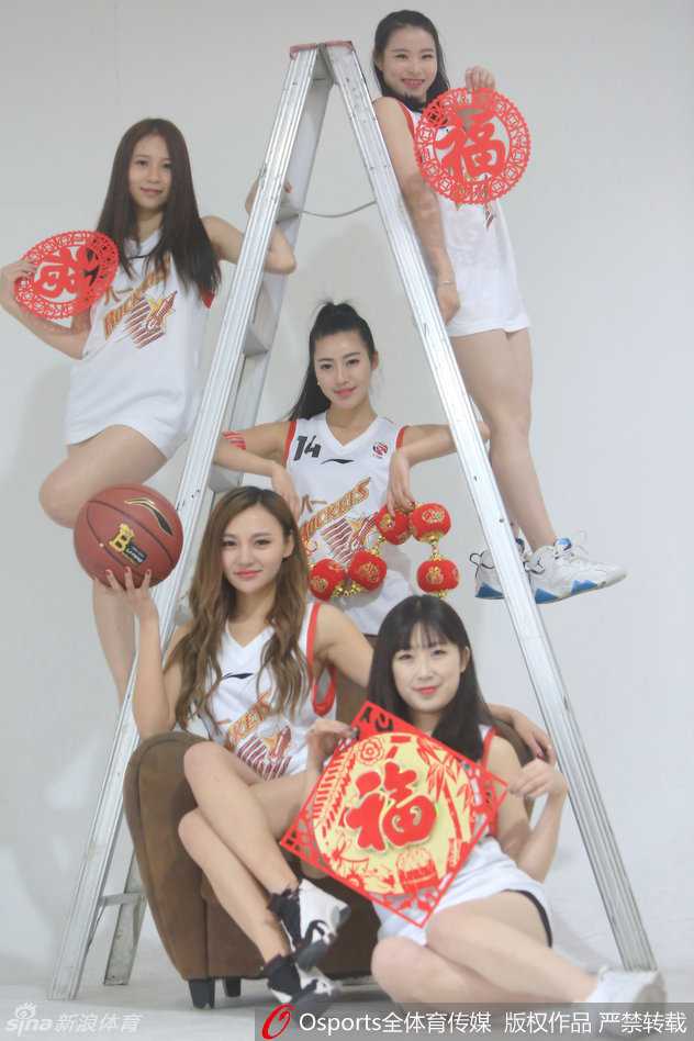 铁军玫瑰绽放新春:八一富邦篮球宝贝的激情与柔美 画面中的两位宝贝亲密相依,一袭红裙娇艳似火,一袭白衣纯洁如雪,她们手持红色折扇,对着镜头做出俏皮的新年手势,浓浓的喜庆氛围仿佛能透过画面感染每一个人。