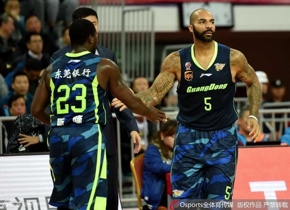 卡洛斯·布泽尔扬起手臂，与队友唐纳德·斯隆用力击掌，两人眼神中充满战斗的欲望，仿佛在无声地宣告：属于我们的时刻到了！