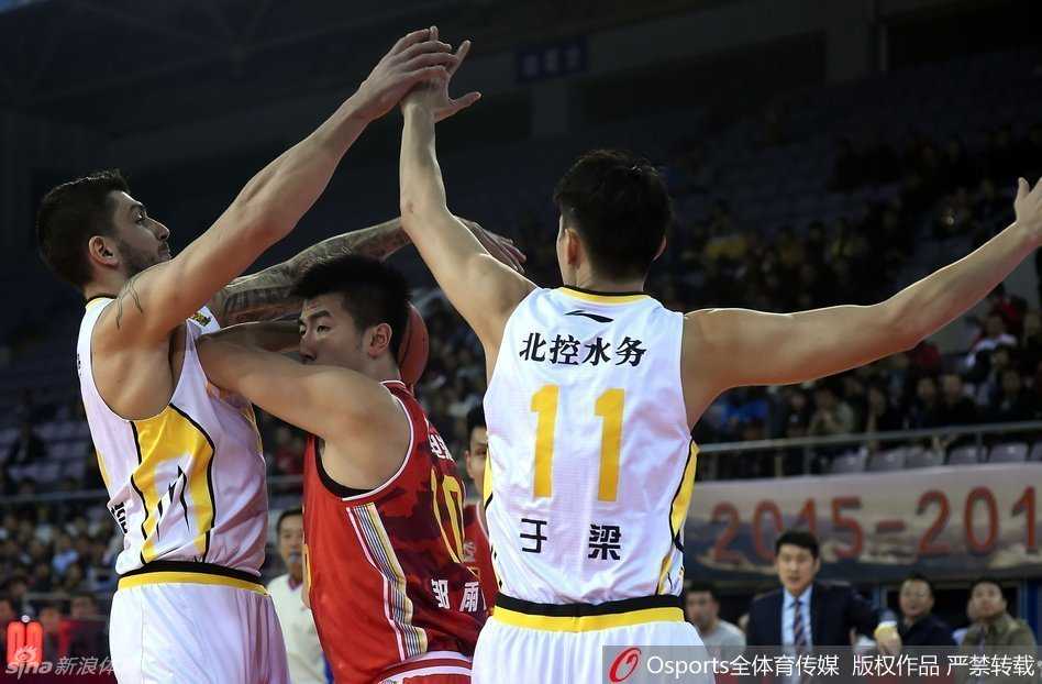 裁判拼命伸出双手拦在八一队主帅阿的江身前，试图平息这位铁帅的怒火，而阿的江则一脸严肃地指向场内，据理力争，场边的空气仿佛都凝固了。