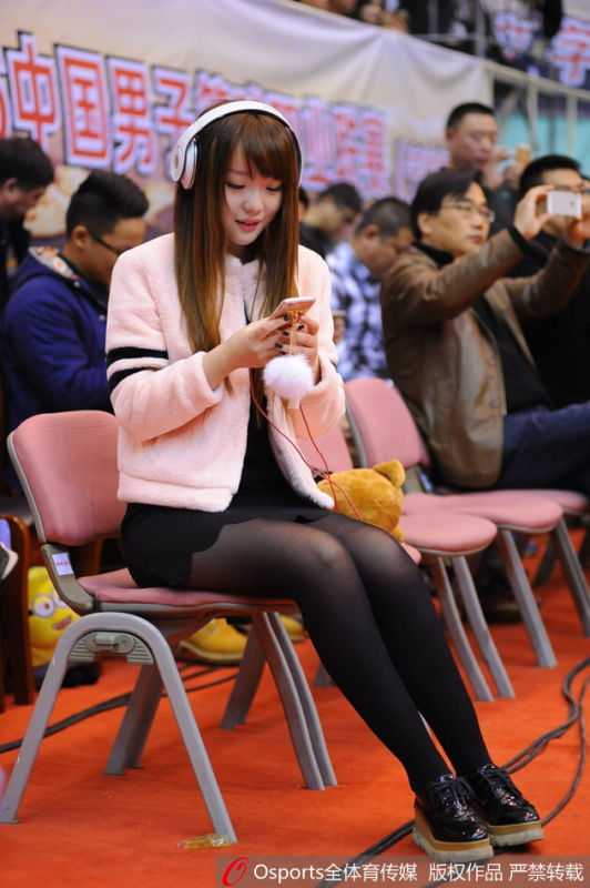 比赛结束后，女球迷开心地与几位身穿八一队服的球员站在一起合影留念，她手中可能拿着签名球衣，笑容灿烂。