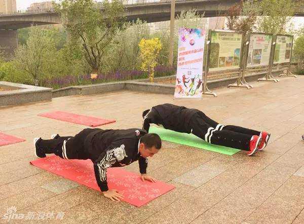 风雨同行,为爱酷跑:西热力江与阿不都的公益征途 阿不都沙拉木在闯关点认真地做着俯卧撑,动作标准有力,路旁的志愿者正在为他计数盖章。