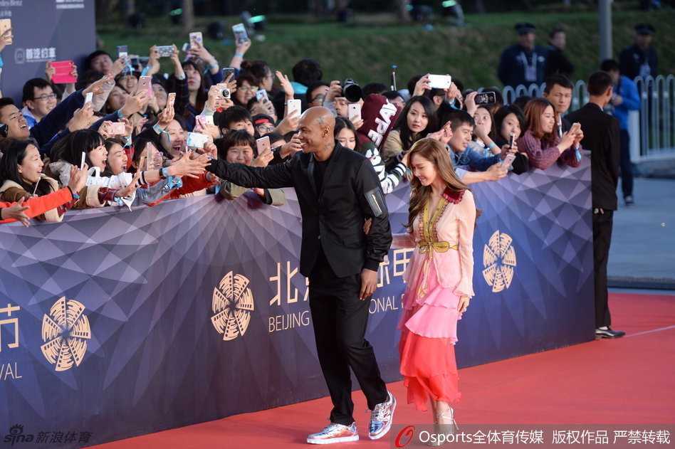 郑秀妍在红毯上优雅转身，裙摆飞扬，她面带标志性的甜美微笑，向现场的影迷和粉丝挥手打招呼，气质出众。