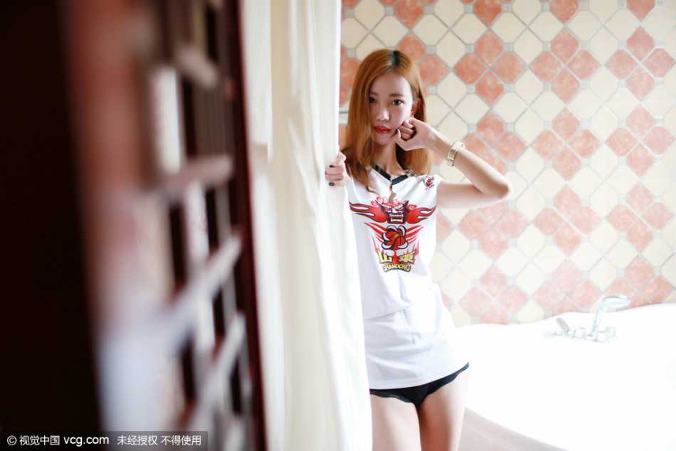 清纯球迷杨柳在酒吧中双手握拳抵在脸颊旁，做出可爱的加油姿势，眉眼间既有为球队揪心的楚楚动人之感，又充满了必胜的坚定信念