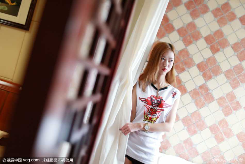 杨柳倚靠在门边独自一人守候，修长笔直的双腿在光影下显得格外吸睛，眼神中透露出对山东高速将士们的无限期盼与支持