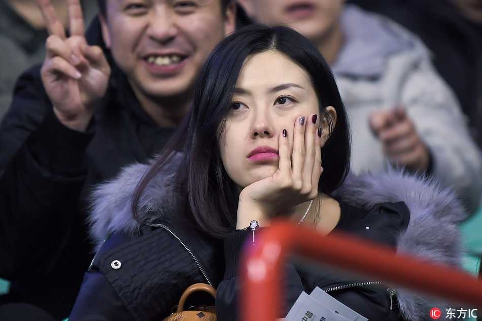 戴着黑框眼镜的知性美女出现在看台，她并没有声嘶力竭地呐喊，而是安静地观察着场上局势，嘴角带着一丝专业的微笑，仿佛正在心中分析着接下来的战术走向。