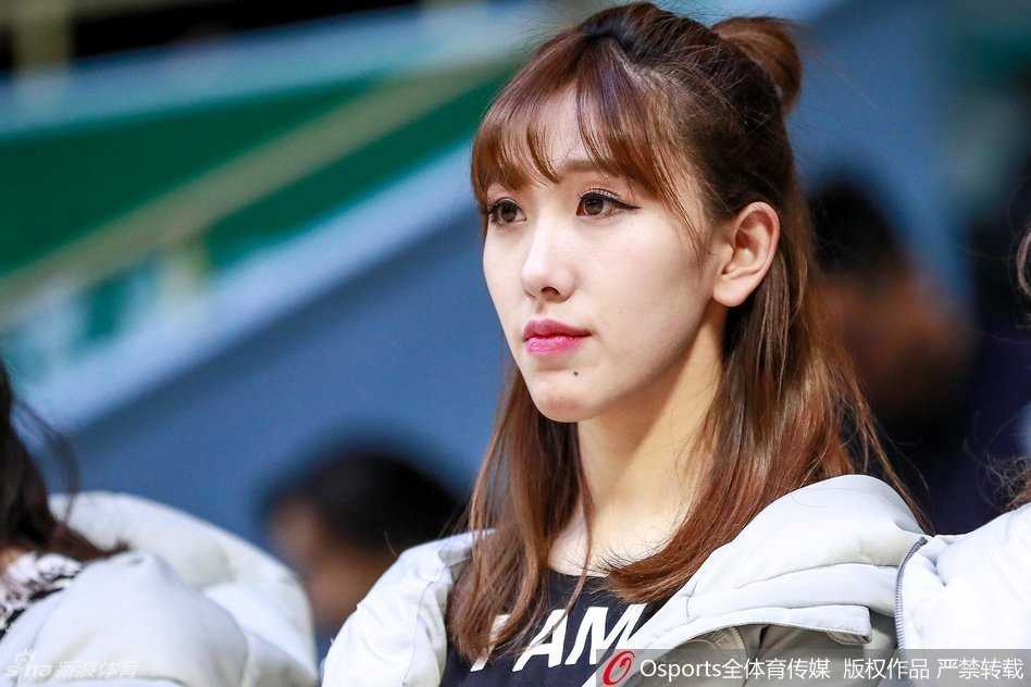 一位篮球宝贝背对镜头扭动腰肢，马尾辫在空中划出优美弧线，紧身衣勾勒出的背部线条展现出舞蹈的柔韧与力度。