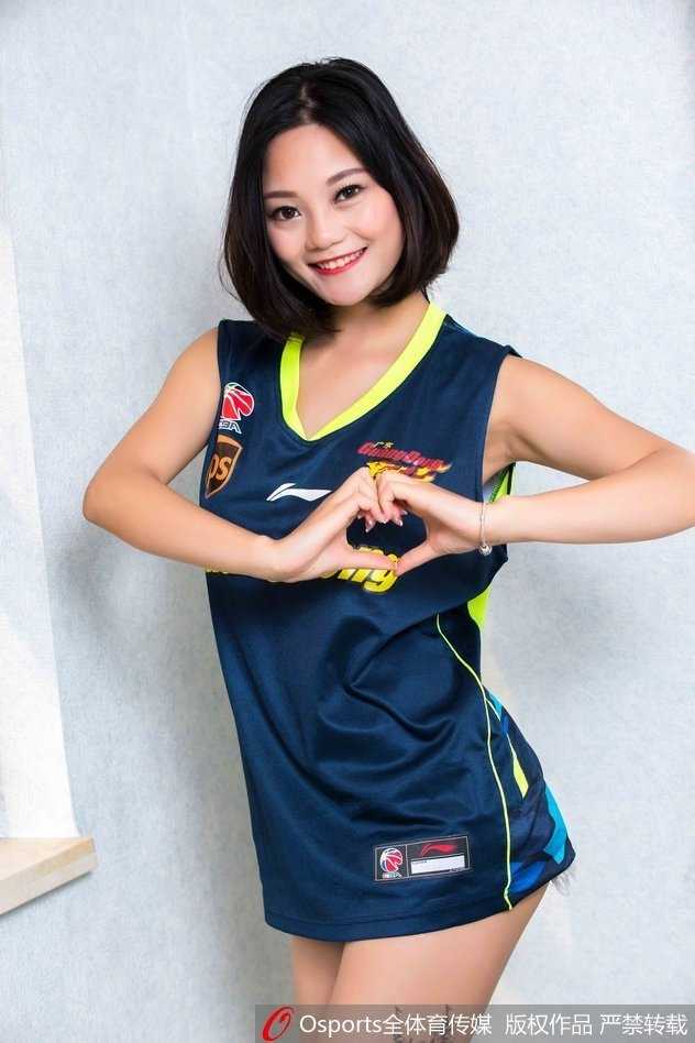 在球场灯光下，篮球宝贝侧身而立，修长的腿部线条与身上的广东队球衣相得益彰，展现出体育与美的结合。