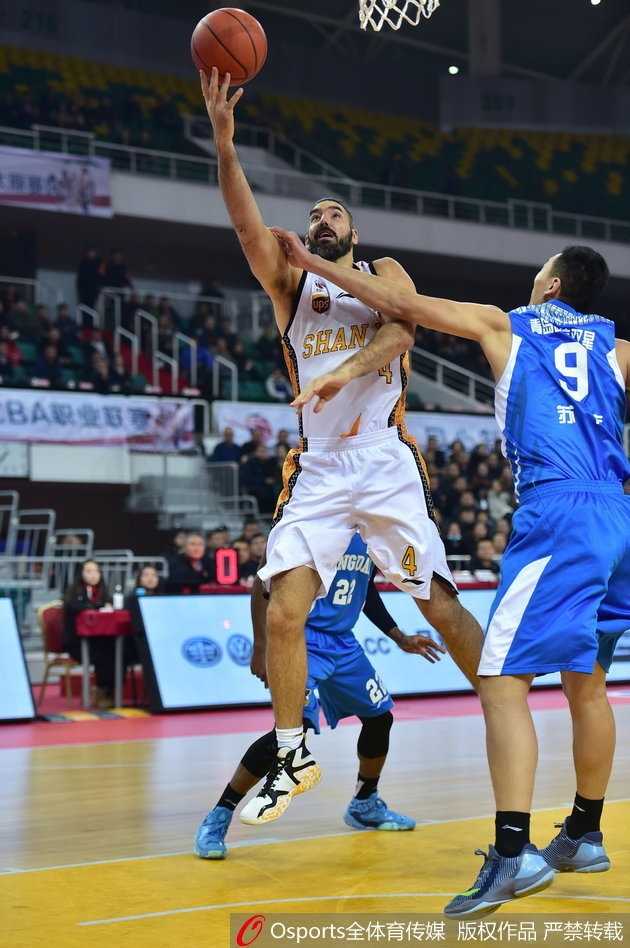 山西队外援斯科拉在青岛队内线球员的严密防守下，依然稳健地运用梦幻脚步勾手投篮，眼神中充满对胜利的渴望。