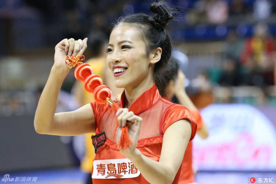 在灯光璀璨的球场中央，一位领舞的拉拉队宝贝展现出极佳的柔韧性，她的一字马动作惊艳全场，周围队友们则以整齐划一的队形散开，共同构成了一幅力与美完美融合的画面。