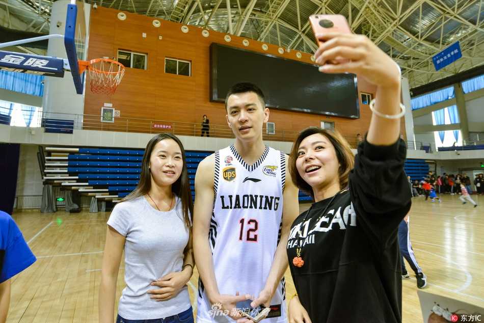 面对粉丝们的热情合影要求，杨鸣展现出了东北大男孩的亲切笑容，他微微低头配合女粉丝的身高，画面充满了温暖的宠粉气息。