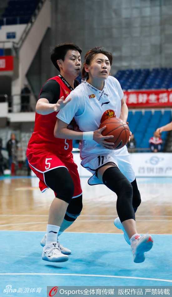 北京队邵婷运球突破，遭遇新疆队王丽丽和迪拉娜的包夹防守，三人对抗激烈，邵婷表情坚毅寻找传球机会。