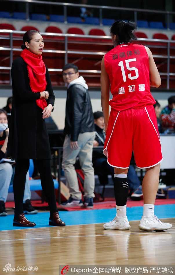 新疆队王丽丽外线持球，面对防守球员干拔跳投三分，篮球在空中划出一道美丽的弧线直奔篮筐。