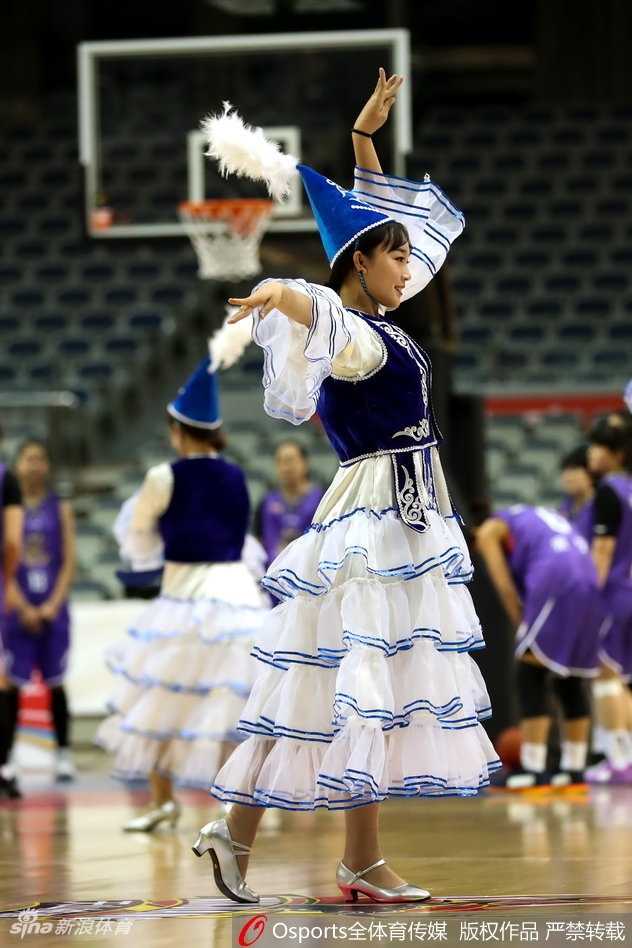 中场休息时，啦啦队变换了更富激情的舞蹈套路。队员们张开双臂，身体舒展到极致，仿佛要拥抱整个球馆的热情。背景里巨大的广告牌和观众席上挥舞的充气棒，共同烘托出浓厚的赛场氛围。