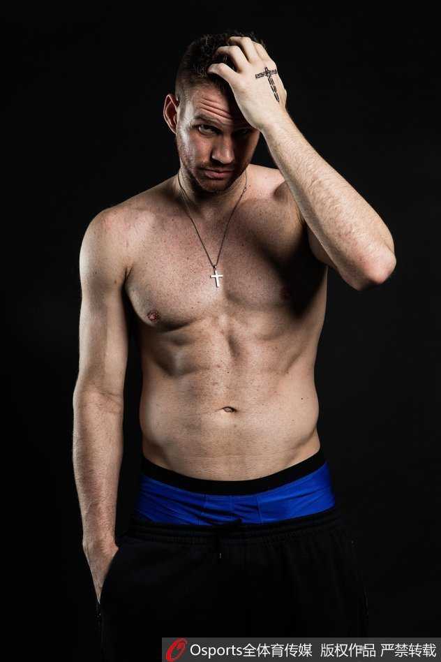 扎克兰多夫赤裸上身，展现出雕塑般的肱二头肌与宽阔的背阔肌，眼神坚毅望向前方，力量感十足