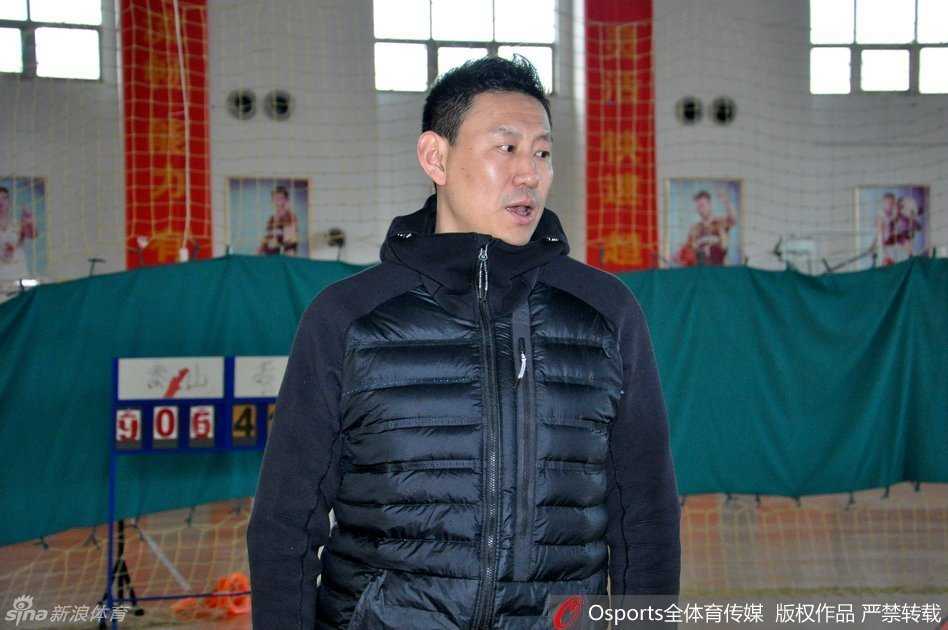训练场上，李楠神情专注地为山东队员进行战术指导，他手托篮球比划着跑位路线，军人出身的他举手投足间透露出对训练细节的严格要求。