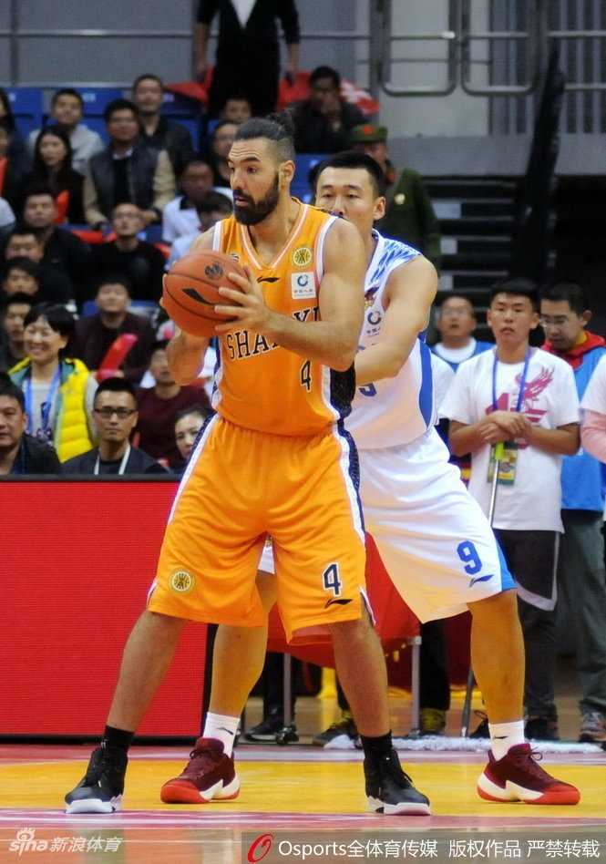 斯科拉在青岛队内线高高跃起，奋力抢下进攻篮板，他身边的防守球员只能望球兴叹。