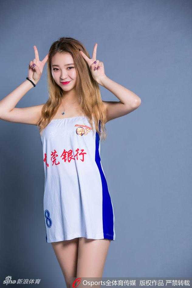 宝贝俏皮地坐在地上，双手轻轻托腮，眼神灵动活泼，展现出卡哇伊的一面，身后是空旷的球场看台。