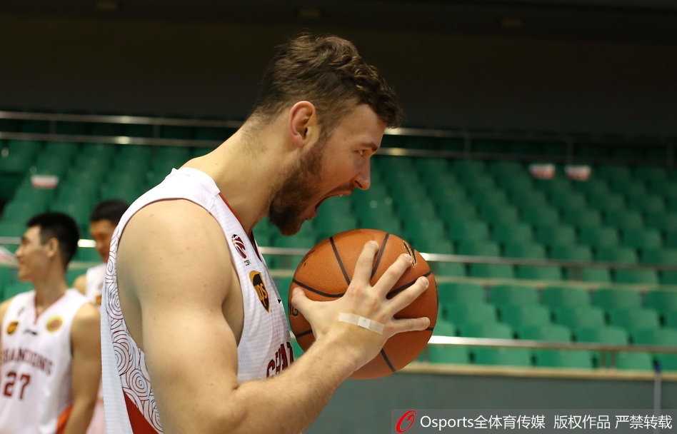 丁彦雨航在拍摄间隙与队友打闹，他试图推开搞怪的队友，但嘴角已经忍不住上扬，旁边的其他队员也被逗乐，现场充满了欢笑声。