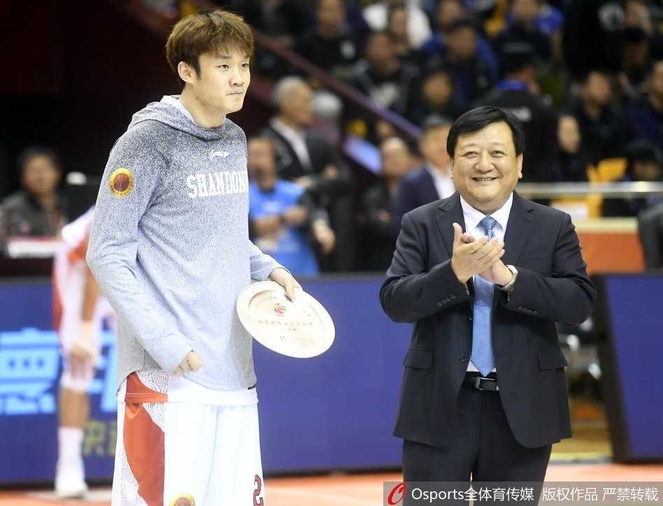 聚光灯下的丁彦雨航神情专注，汗水浸湿了他的球衣，胸前的队徽在灯光下熠熠生辉，见证着他对胜利的渴望与执着。